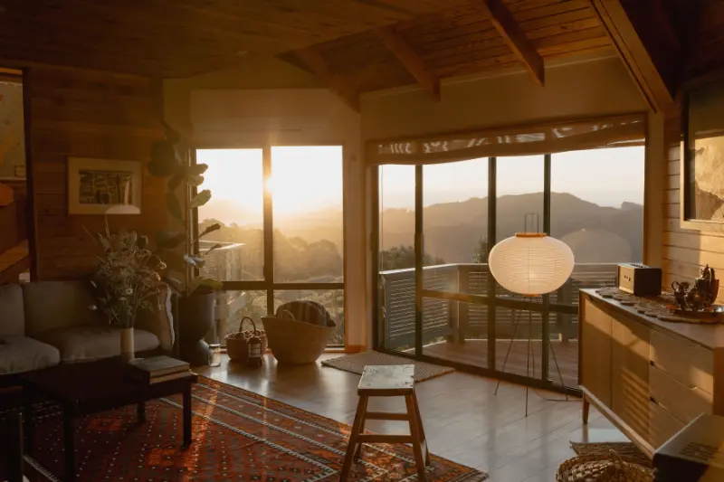Buffalo Lodge lounge at sunset with panoramic views over the Coromandel coastline.